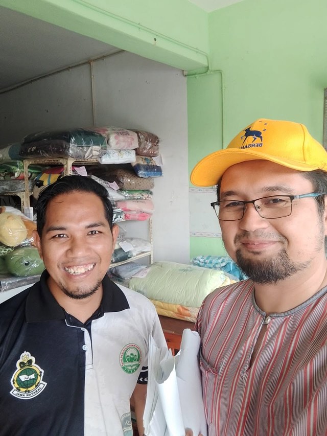 Aman Akil bergambar bersama seorang warga setempat di dalam kedai.