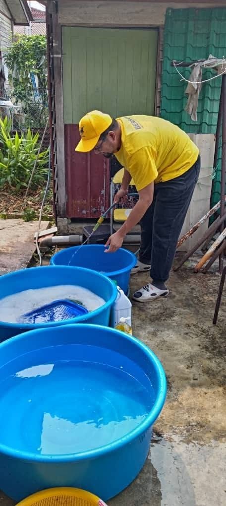 Seorang ahli pasukan mengurus peralatan di ruang mencuci dengan besen biru.