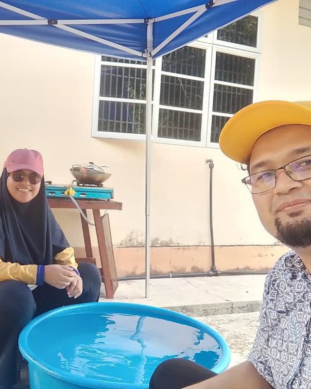 Suasana di ruang mencuci pinggan di bawah khemah biru.
