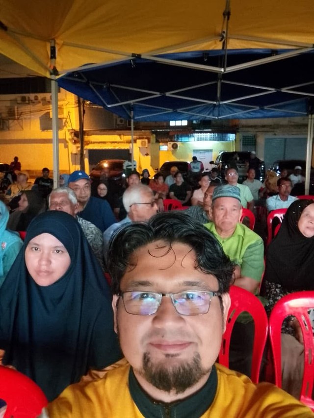 Foto bersama hadirin yang duduk di bawah khemah pada malam program.