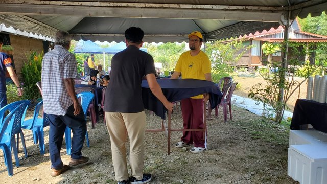 Aman Akil membantu mengangkat meja bersama peserta di ruang kenduri.