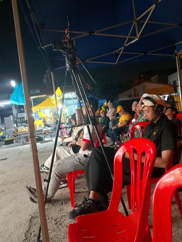 Hadirin dan peralatan rakaman di bawah khemah semasa ceramah berlangsung.