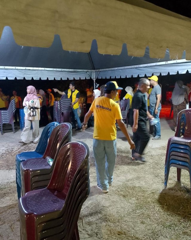 Petugas mengumpulkan dan menyusun kerusi di bawah khemah program.