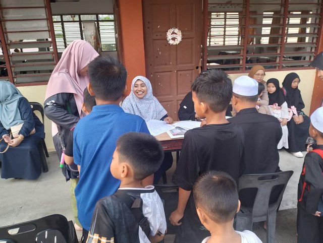 Pelajar dan petugas di meja pendaftaran program.