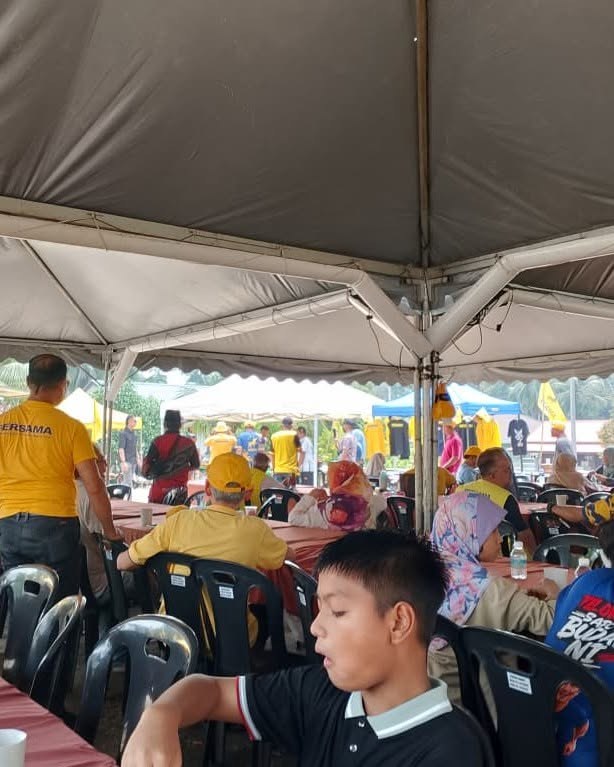 Keluarga dan pengunjung duduk di ruang jamuan kenduri.
