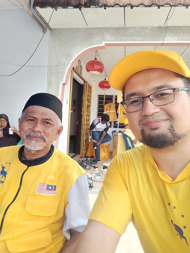Aman Akil bergambar bersama seorang tetamu semasa kenduri.