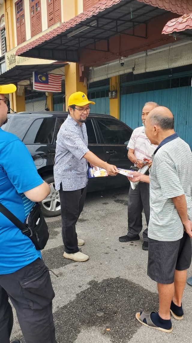 Aman Akil bersalaman dan menyampaikan risalah kepada warga setempat di hadapan deretan kedai.