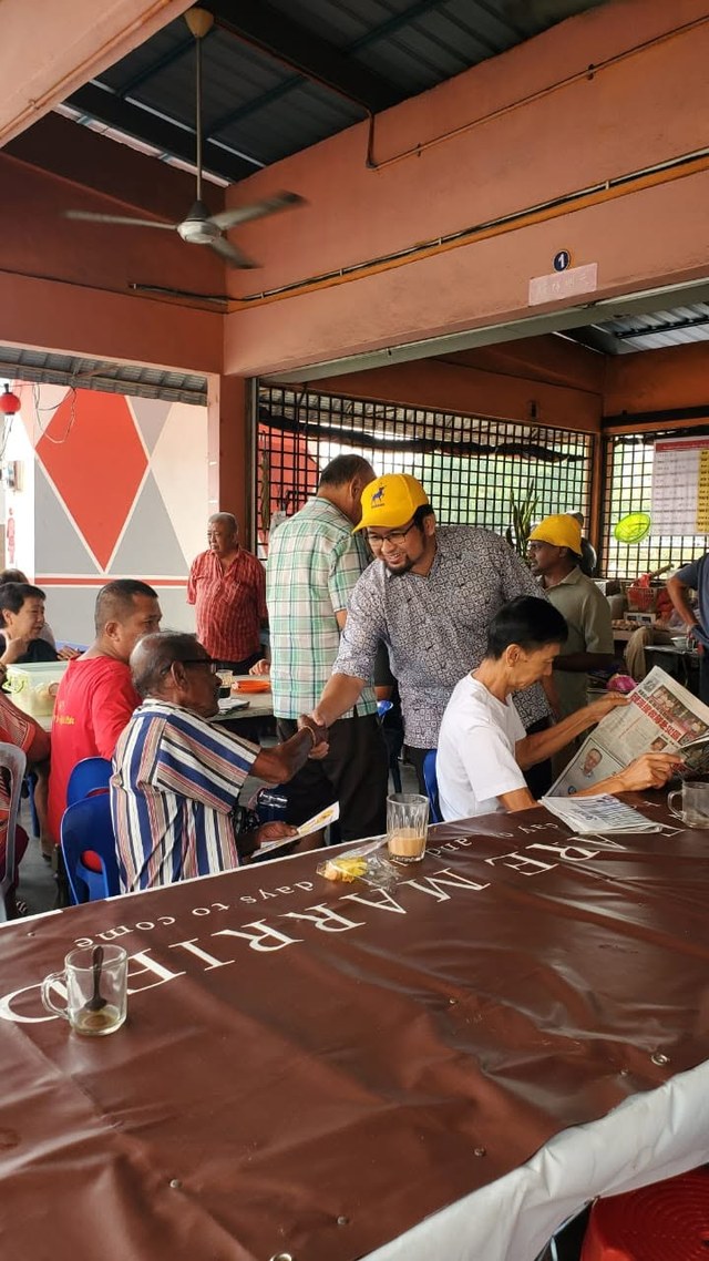 Aman Akil menyapa pengunjung yang duduk di sebuah kedai makan.