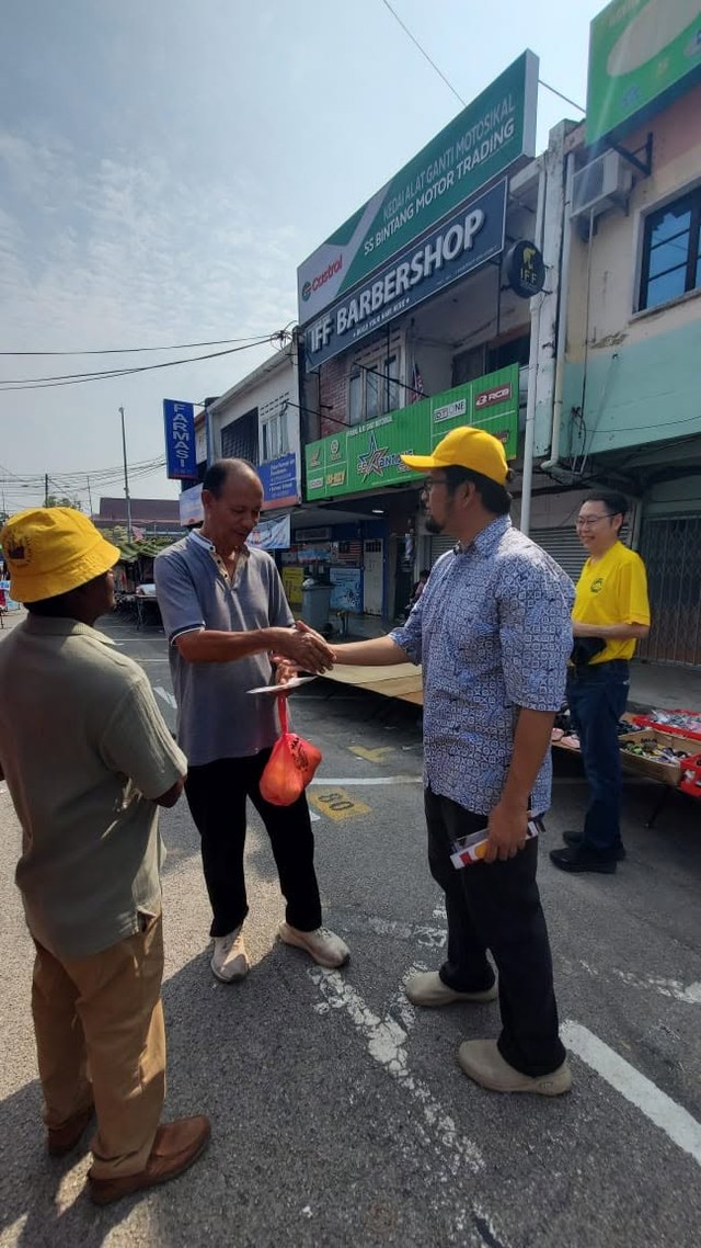 Aman Akil menyampaikan risalah kepada seorang warga setempat di tepi jalan.